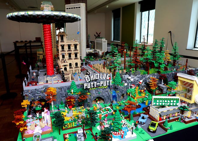 A flying saucer (top left) hovers over a large LEGO display at the Columbus Museum of Art that includes Downtown Columbus buildings.